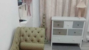A room with a green sofa, a white dresser, and a lamp. - The Shepherd Bush Stay in London by Gndj (London)