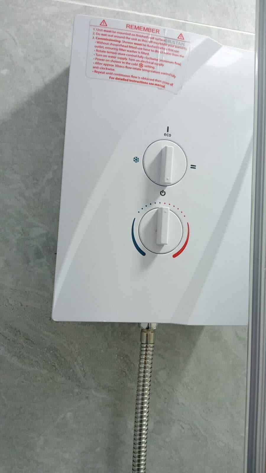 A control panel with two knobs and a warning label.