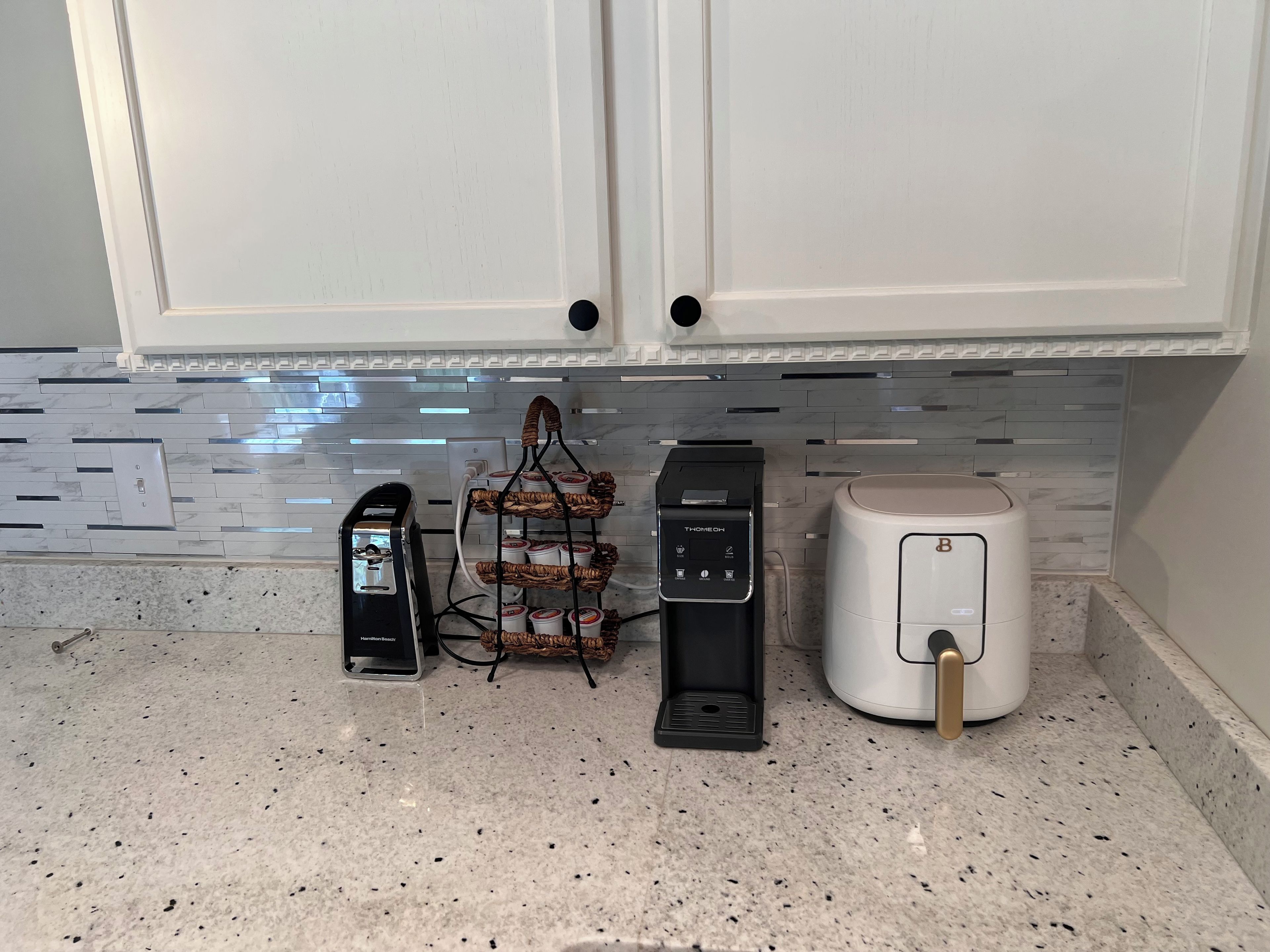 Une cuisine équipée d’une machine à café, d’un grille-pain et d’un appareil à pain, le tout posé sur le plan de travail.