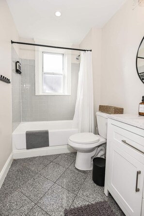 Un baño con bañera, inodoro y cortina de ducha.