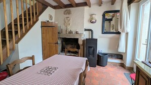 Um quarto aconchegante com escada de madeira, lareira, cama com colcha estampada e janela com vista.