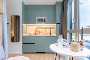 A modern kitchen with a built-in microwave, a large window, and a dining area with a table set for two.