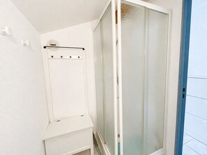 Ein Badezimmer mit Duschkabine, Handtuchhalter und Toilette.