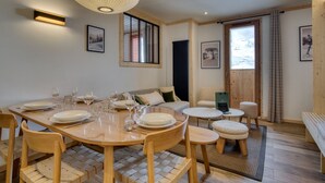Un comedor con una mesa de madera, sillas y una lámpara colgante.