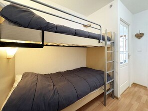 A bunk bed with a ladder, a bedside table, and a wall-mounted light fixture. - Apartment Les Orres 1800 with pool access, sleeps 6 (Les Orres)