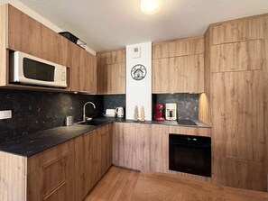 A compact kitchen with wooden cabinets, a microwave, a coffee maker, and a dishwasher. - Apartment Les Orres 1800 with pool access, sleeps 6 (Les Orres)