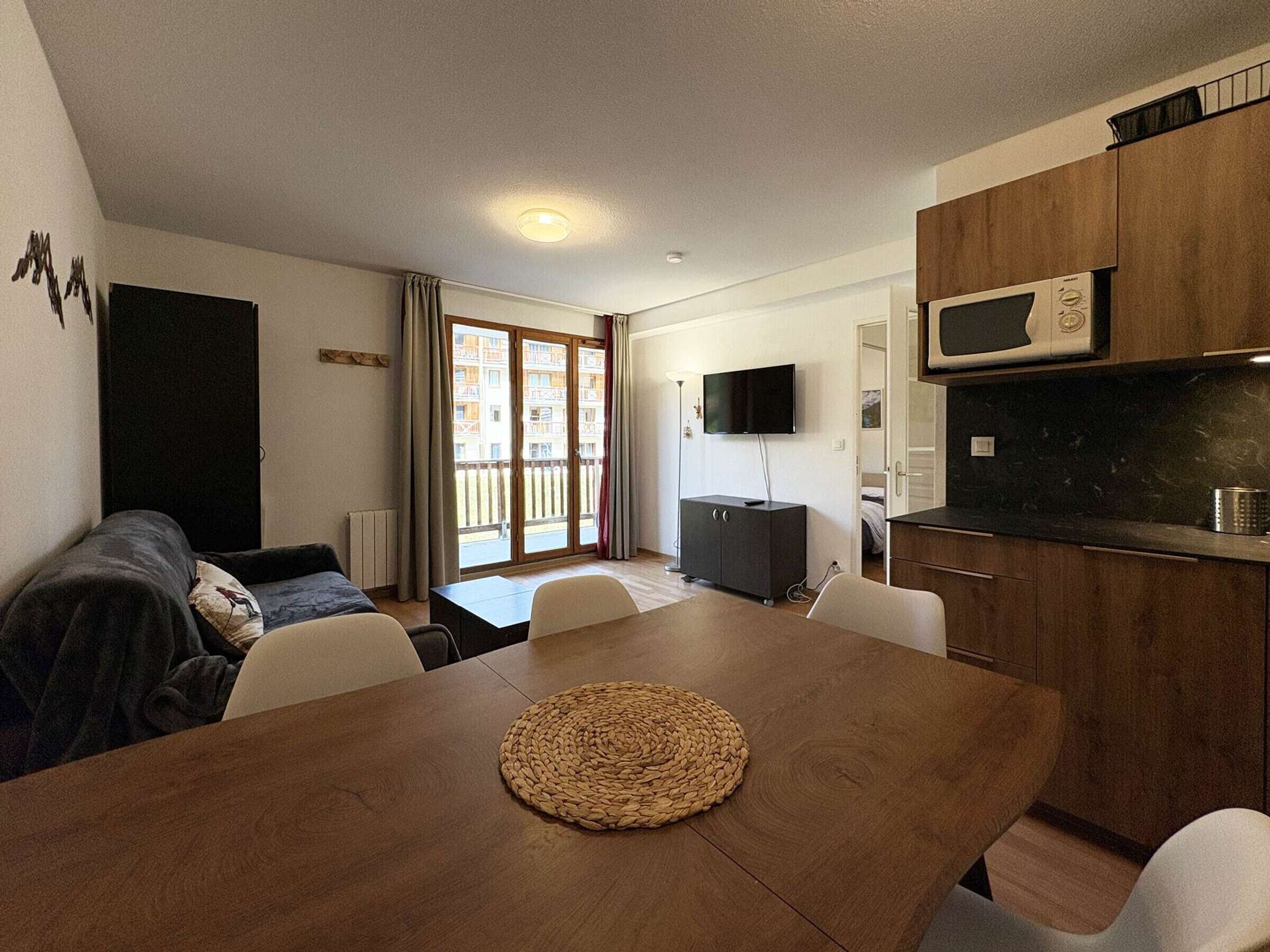 Un espacio habitable compacto con kitchenette, comedor y sofá.