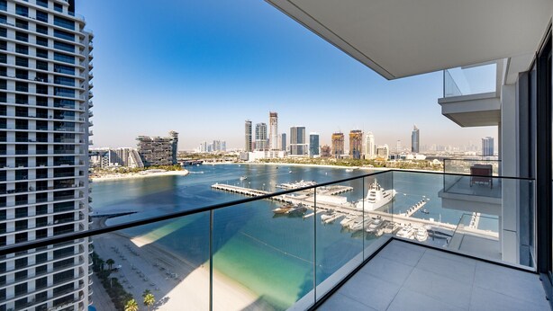A high-rise building with a view of a marina and city skyline. - Modern Beachfront 3BR Apt | Near Marina & JBR (Dubai)