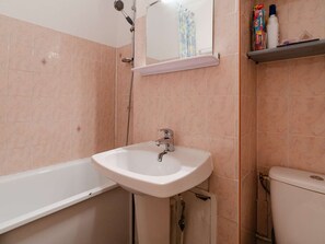 Ein Badezimmer mit Waschbecken, Badewanne, Toilette und Spiegel über dem Waschbecken.