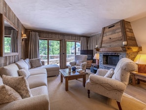 A cozy living room with a fireplace, comfortable seating, and large windows. - Elegant apartment, parking - 6 guests (Val-d'Isère)