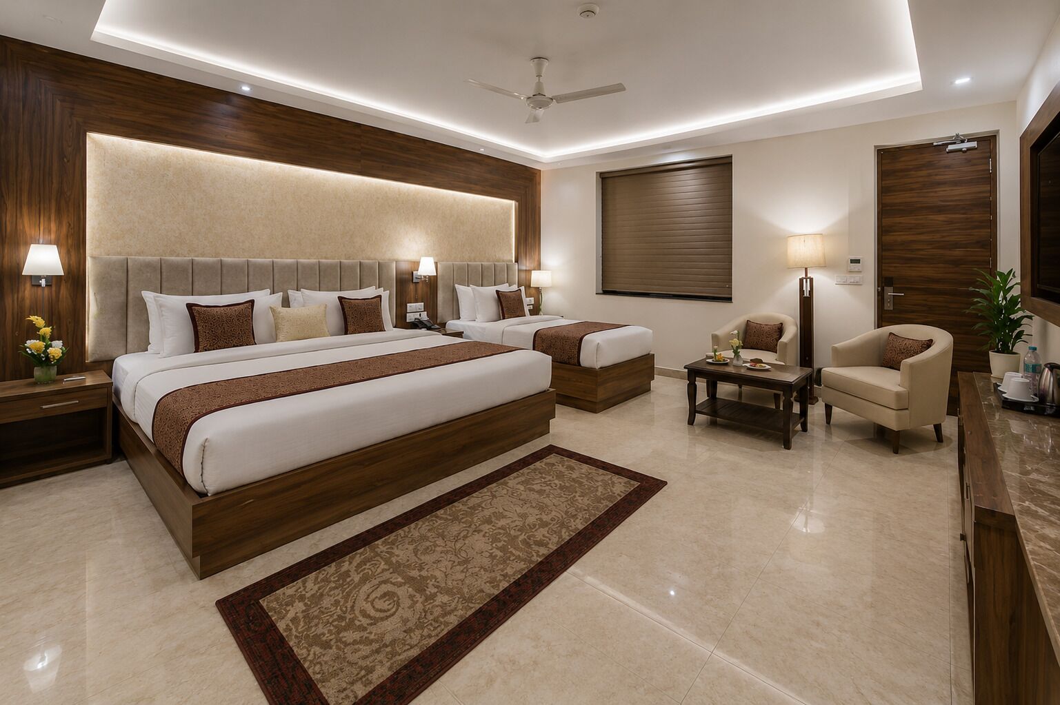 A modern hotel room with a large bed, two bedside tables, a sofa, a coffee table, and a TV.