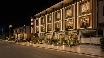 Un hotel con fachada moderna, varias ventanas y una entrada bien iluminada.