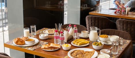 A dining table with breakfast items, including toast, eggs, and beverages.