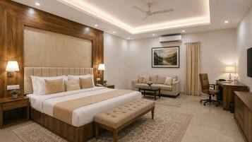 A hotel room with a large bed, a sofa, a desk, and a ceiling fan.