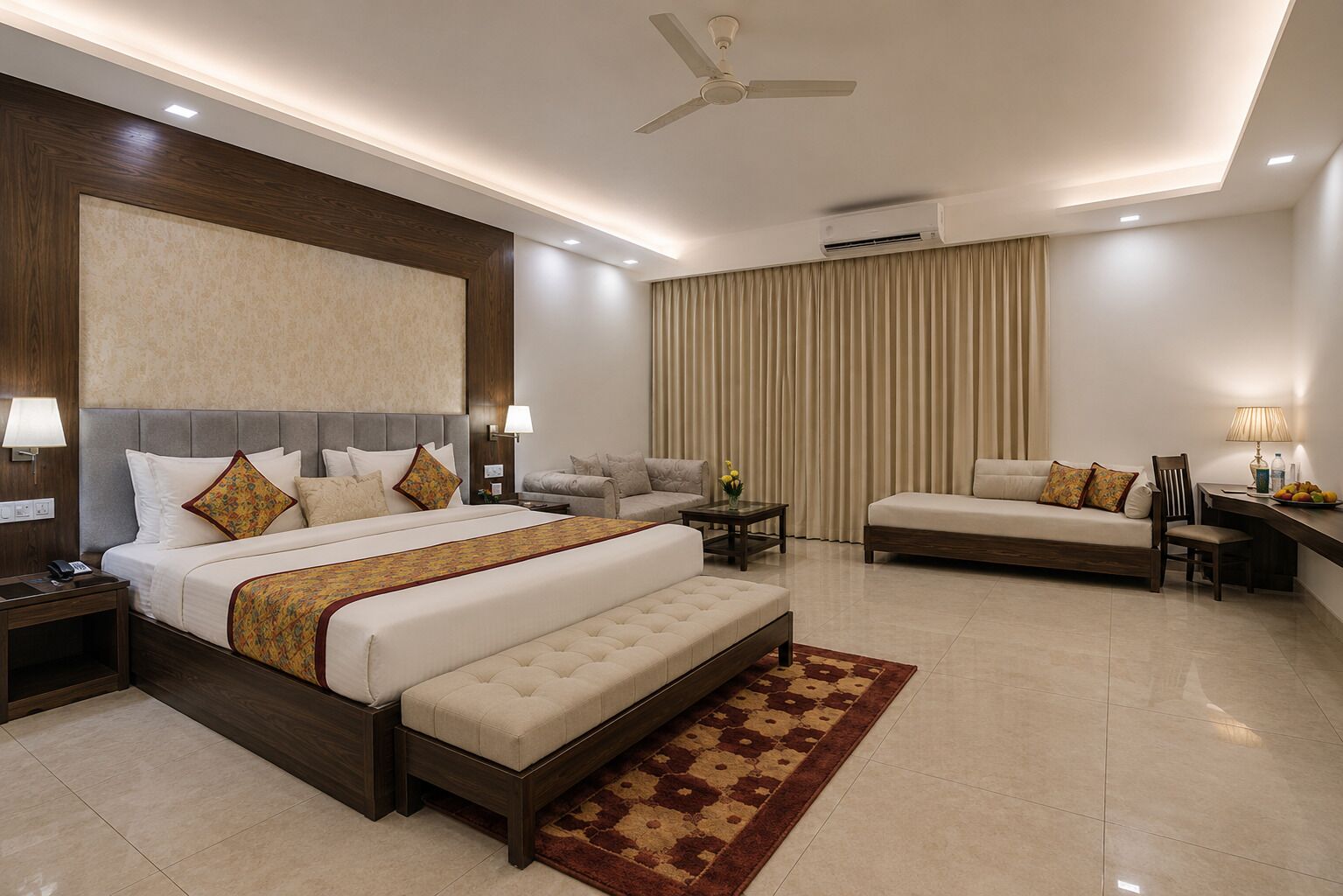 Habitación de hotel con una cama grande, un sofá, un escritorio y un ventilador de techo.