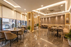 A modern restaurant with marble flooring, high ceilings, and a view of the city.