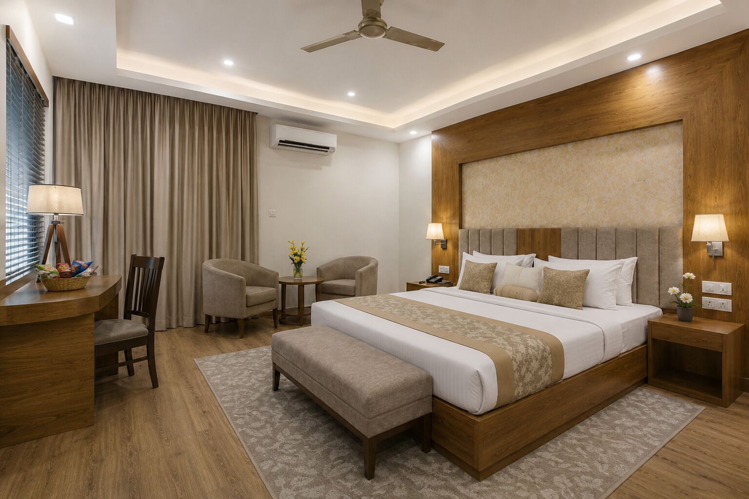 Una habitación de hotel moderna con una cama grande, dos sillones, un escritorio y un ventilador de techo.