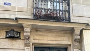 A double door with a brass handle, flanked by stone columns, and a balcony with wrought iron railings above. - Comfortable & Peaceful Apartment, Latin Quarter - Newly Renovated (Paris)