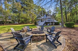 A house with a deck, a fire pit, and outdoor seating. - Stunning lakefront views for a perfect sunset! (Eatonton)