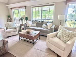A living room with a sofa, armchairs, a coffee table, and a window with a view. - Stunning lakefront views for a perfect sunset! (Eatonton)
