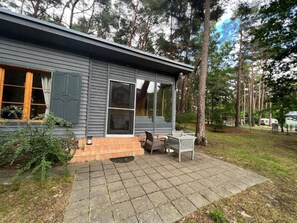 A modern house with a patio, a covered outdoor seating area, and a large window. - Holiday Home With Private Garden, Close to the sea (Rewal)
