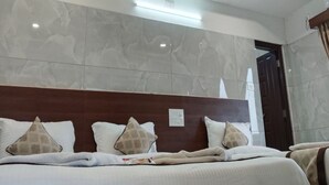 Habitación de hotel con cama, techo de madera y pared de mármol.