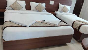 Una cama doble con estructura de madera, ropa de cama blanca y muchas almohadas.