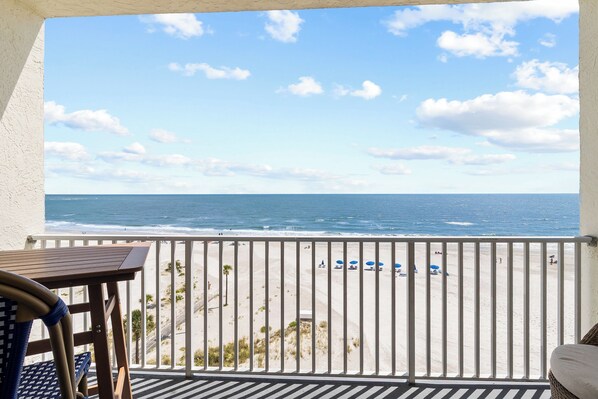 A balcony with a view of the ocean, a table, and chairs. - Beach Front Near John's Pass - Sea Breeze #602 (Madeira Beach)