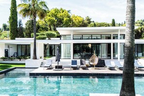 A modern house with a swimming pool, lounge chairs, and a tropical garden. - Exceptional Villa With Pool 5br/10p - Mougins (Mougins)