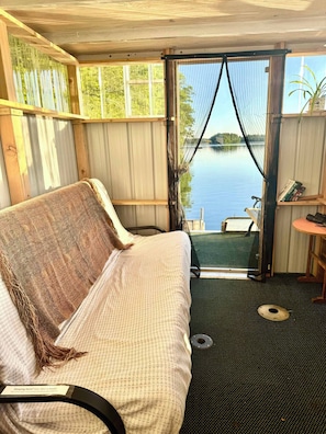 Una habitación con una cama, una mesita y vista a un cuerpo de agua.