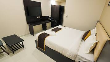 Habitación de hotel con cama, escritorio, televisor de pantalla plana y armario.