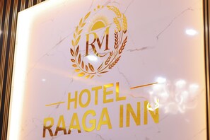 A sign with 'HOTEL RAAGA INN' and a logo with 'RM' and laurel wreaths. - Hotel Raaga Inn (Tirupati)