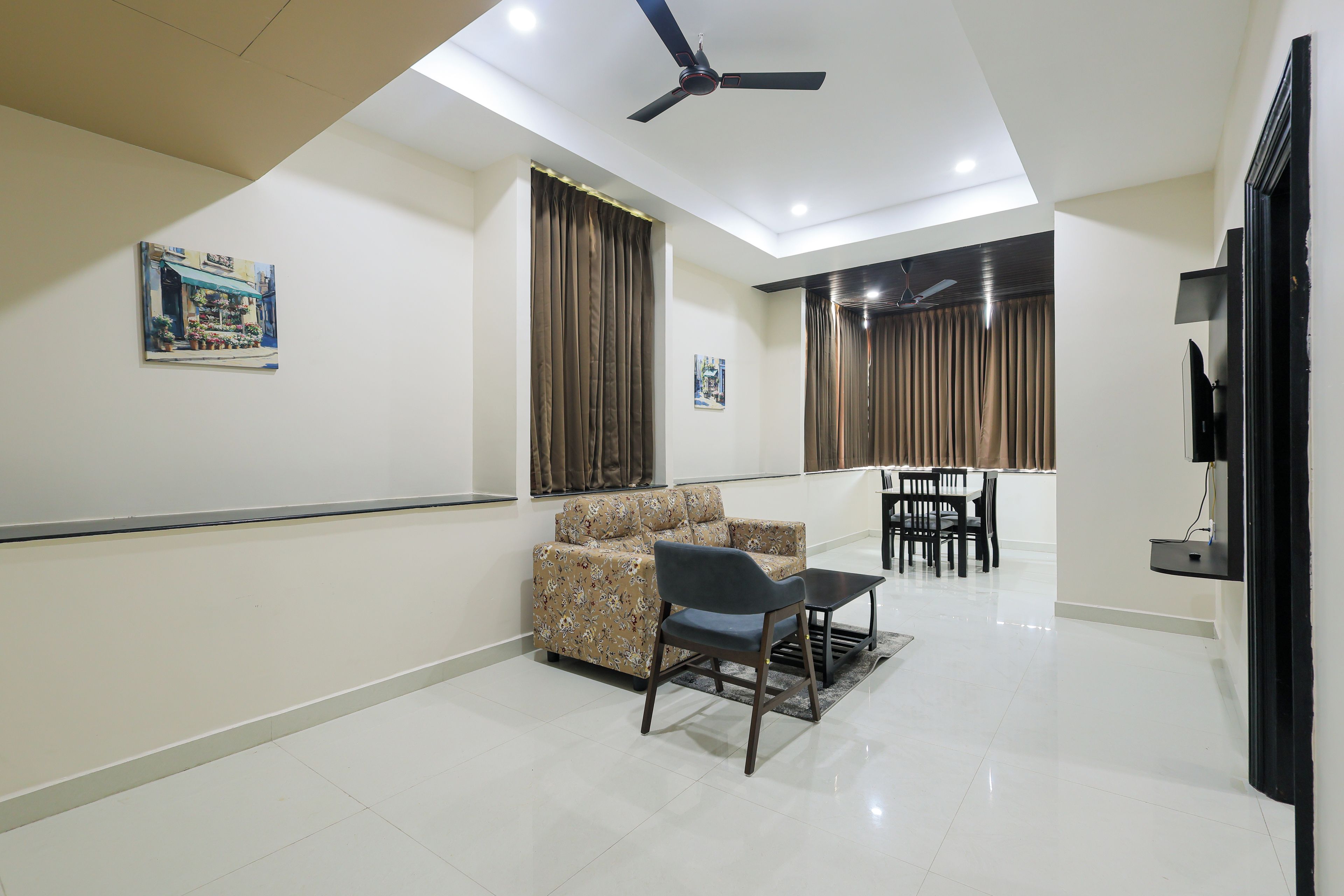 Uma sala de estar moderna com sofá, mesa de centro e área de jantar com cadeiras e mesa.