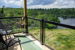 Ein Balkon mit Blick auf einen Fluss und ein Waldgebiet.