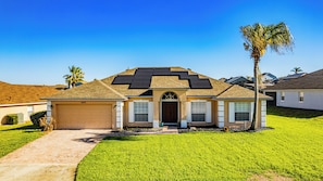 A single-story house with a garage, solar panels, and a well-maintained lawn.