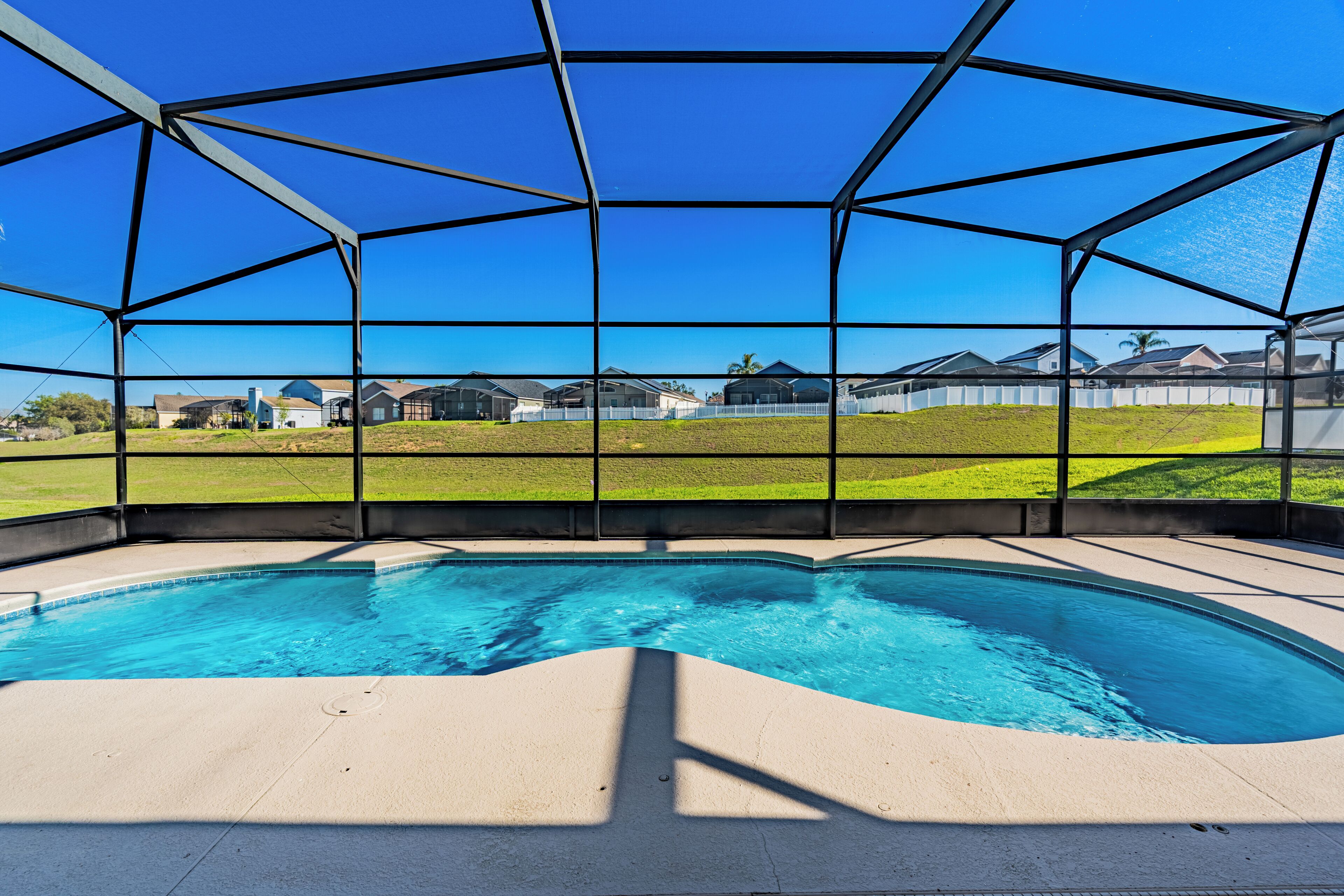 A swimming pool with a clear view of houses in the background.