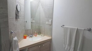 Chuveiro, toalhas de banho, sabonete, papel higiênico