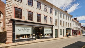Vista de una calle con un edificio y una tienda llamada 'Coxon & Coxon'.
