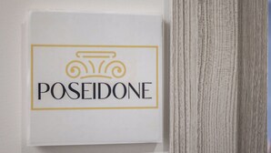 A sign with the word 'POSEIDONE' and a classical column icon. - Alla Corte degli Dei (Tropea)