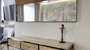 Quarto moderno com uma escrivaninha de madeira, um espelho e uma luminária.