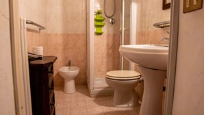 Une salle de bain équipée de toilettes, d’un bidet et d’une douche.