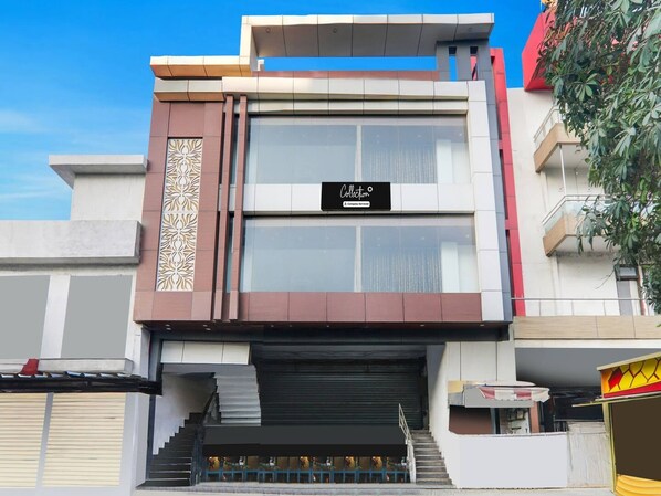A modern building with a large sign, a staircase, and a gated entrance. - Super Collection O Quila Road (Lucknow)