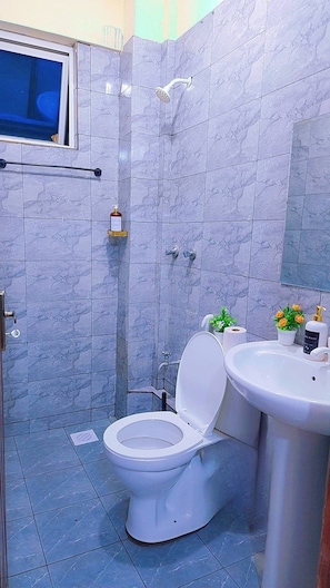 A bathroom with a toilet, sink, and shower. - Modern Coastal Apartment - Lift/Elevator Access,7 mins from beach, 24hr security (Mombasa)