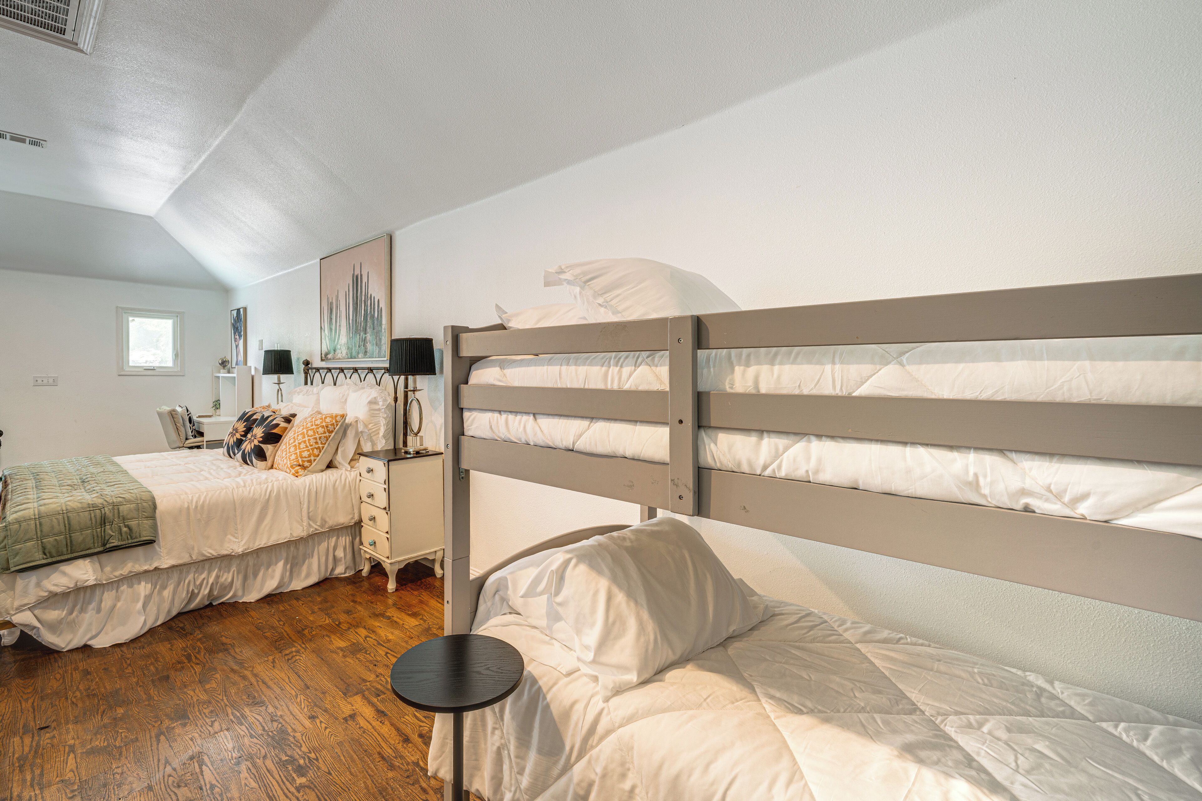 Une chambre avec deux lits superposés, une table de chevet, une lampe et une fenêtre.