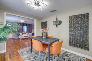 Un comedor con una mesa, sillas y un jarrón decorativo.