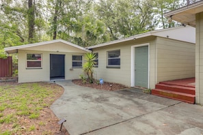 A two-story house with a front porch, a garage, and a small garden area.