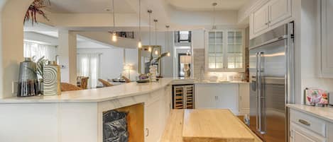 A modern kitchen with a central island, stainless steel appliances, and pendant lighting.