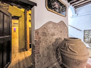 Eine Steinsäule, eine Holztür und ein großer Topf.