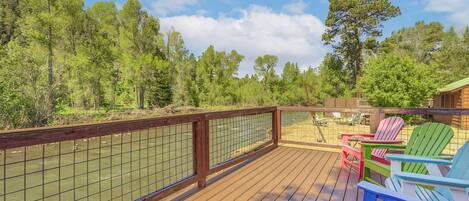 A wooden deck with a view of a river, surrounded by trees.