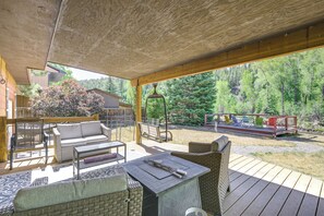 An outdoor patio with wicker furniture, a barbecue grill, and a view of a forested area. - Outdoor Oasis! Angler's Paradise in Pagosa Springs (Pagosa Springs)